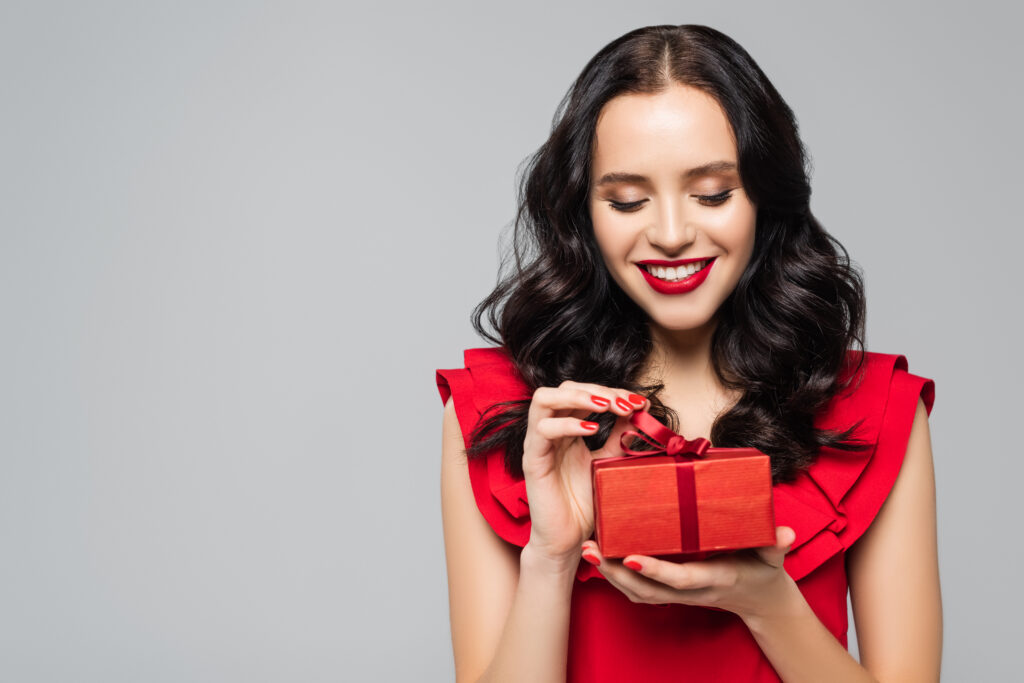 Cheerful,Woman,In,Ruffled,Dress,Pulling,Ribbon,On,Gift,Box